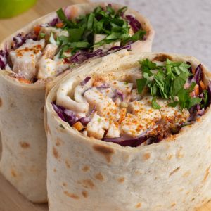 Jollof chicken wrap sliced in half showing filling